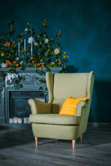 古色古香的手臂椅在淺綠色復(fù)古70年代樣式隔絕在房間里。靜定綠色手臂椅子與黃色枕頭在客廳與壁爐的生活。立式攝影. 古玩店