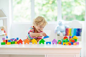 孩子玩五颜六色的玩具块。小男孩建筑塔的块玩具。为幼儿提供教育和创意玩具和游戏。婴儿在白色的卧室与彩虹砖。儿童在家