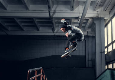 年輕的滑板運動員在室內(nèi)滑板公園的迷你坡道上表演一個把戲. 