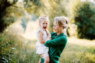 抱著小女兒的大自然中的年輕母親