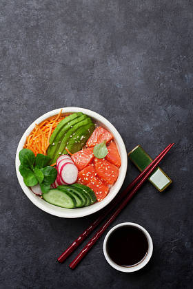 用三文鱼和蔬菜、茶壶和杯子戳碗。传统的夏威夷生鱼沙拉。顶视图