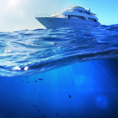 熱帶大海中美麗的陽光海景探險船，海底深藍(lán)色，被水線隔