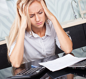 Sad woman looking at picture of bill