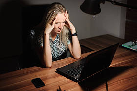 强调女商人坐在办公室桌前的画像