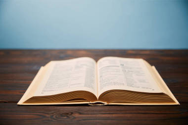 在木桌上的書的選擇性焦點(diǎn)與復(fù)制空間隔離在藍(lán)色