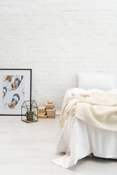 臥室, 枕頭放在空床和書上, 植物和圖片放在地板上