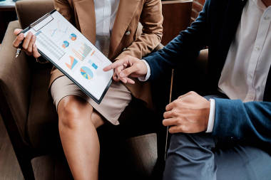 经营理念。商界人士在讨论图表和图形显示出结果，他们成功的团队工作