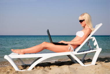 夏季海灘上的白色筆記本可愛的金發(fā)女人