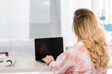 后面的金發(fā)年輕女子使用筆記本電腦與空白屏幕的看法