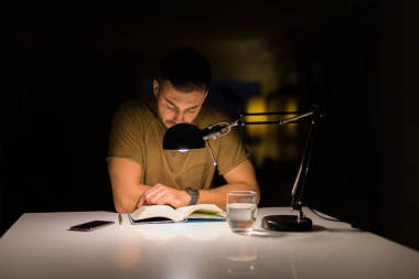 年輕的帥哥在家學(xué)習(xí), 晚上看書