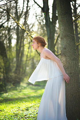 白色的礼服站在户外的优雅时尚新娘