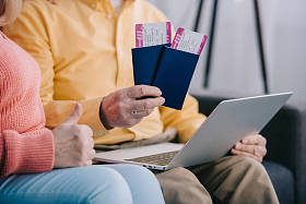 裁剪视图的高级夫妇显示拇指上的标志和持有机票与护照