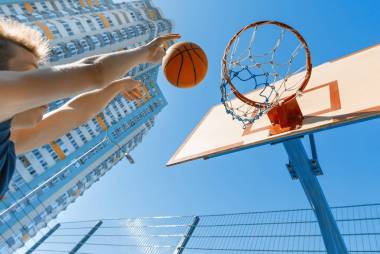 高加索青少年男孩街頭籃球運動員與球在室外城市籃球場