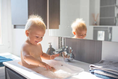 嬰兒在水槽里洗澡。玩泡沫和肥皂泡泡的兒童