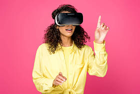 惊讶卷曲的非洲裔美国妇女戴虚拟现实耳机, 用手指孤立在深红色 