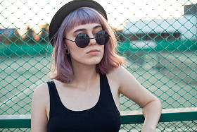 站在栅栏附近的时尚年轻女子