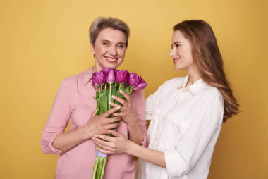 半長的快樂棕色頭發(fā)的女孩祝賀她的母親與假期