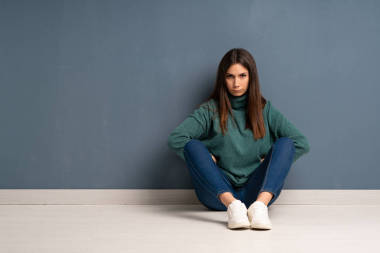 坐在地板上生氣的年輕女子