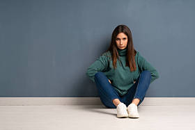 坐在地板上生气的年轻女子