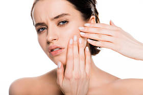 悲伤的黑发女人触摸的脸, 看着相机孤立的白色 