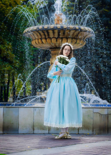 女孩與一束白色的菊花站在噴泉