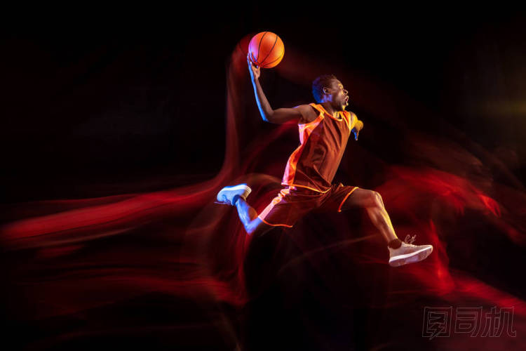 黑暗背景下的年輕籃球運動員