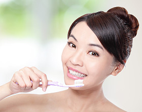 微笑的女人用牙刷清洁牙齿图片