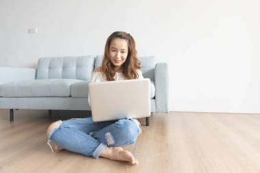 漂亮的亞洲女人在家里使用電腦