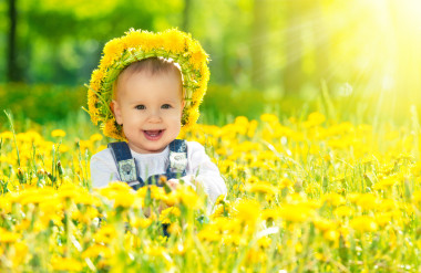 开心宝贝女孩在草地上与黄色的花朵 t 上一个花圈