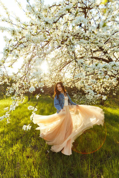 美丽新娘的画像。 结婚的概念。 时尚的婚礼。 巨大的日落之光 她穿着蓝色斜纹棉布夹克和衣服。 春花园