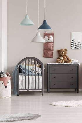 灰色木制婴儿床在时尚的斯堪的纳维亚婴儿卧室内部