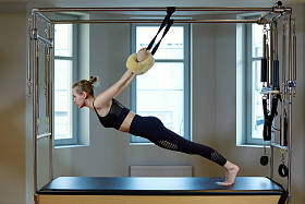 美丽的女孩在模拟器上伸展和训练你的背部, 沉默的手势