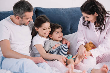 快乐的母亲微笑接近可爱的女儿，儿子和丈夫 