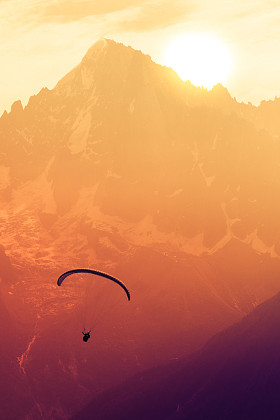 在阿尔卑斯山的山峰棕褐色滑翔伞剪影
