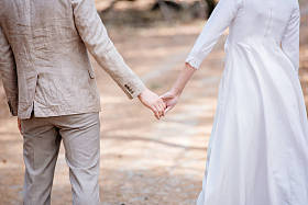 刚刚结婚的夫妇在森林里手牵手的裁剪视图