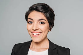 美丽的混合种族女商人微笑在相机隔离在灰色的肖像