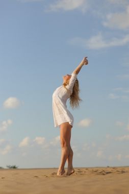 在白色的禮服走在沙漠中的美麗女人