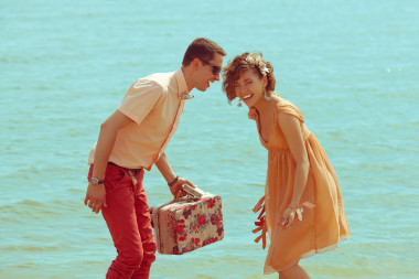 沙灘上散步的情侶?？鞓?lè)的年輕人結(jié)婚時(shí)尚及膝