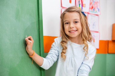可愛的女孩在幼兒園中寫上船