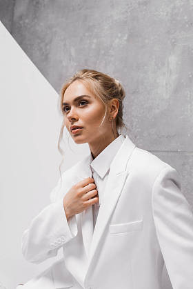 美丽和时尚的年轻金发女郎在白色和灰色 