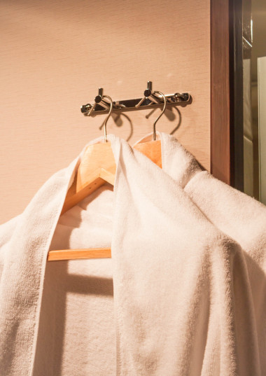 在酒店房間里的木衣架上的白毛巾