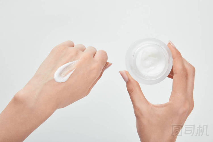 裁剪視圖的婦女與奶油在手和皮膚隔離在白色