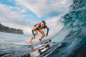 冲浪板上美丽的冲孩。冲浪时在海洋中的女人。冲浪者和桶波