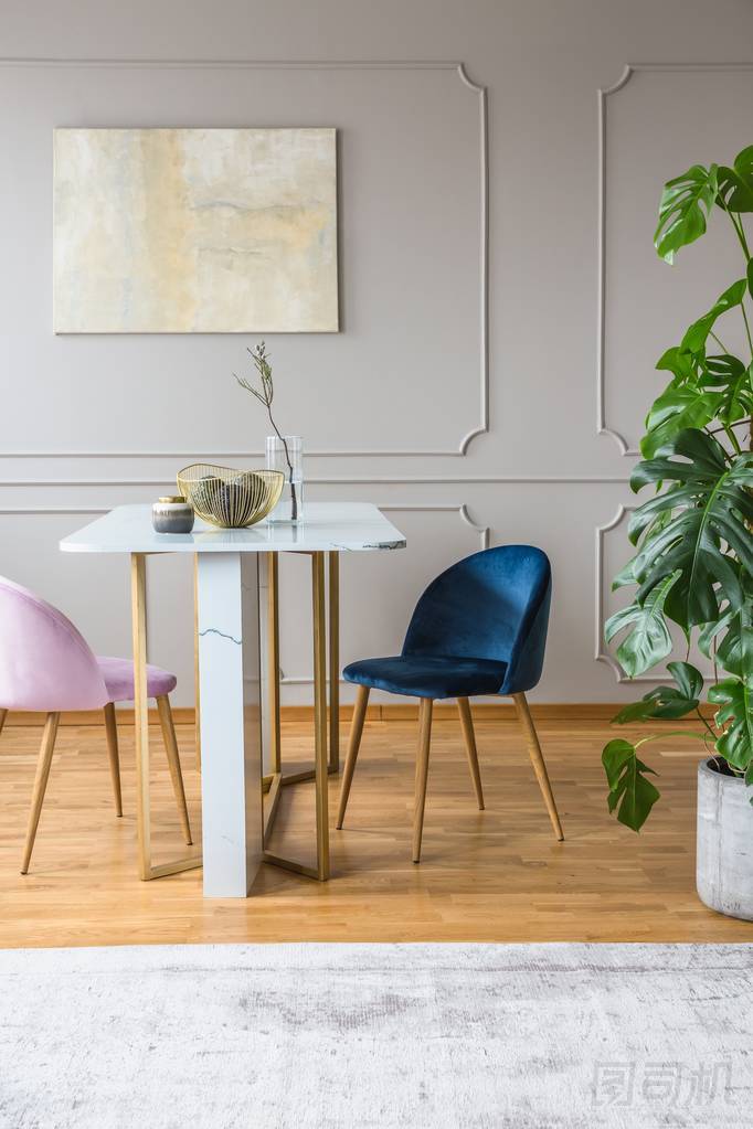 餐廳的灰色和金色桌子，配有粉紅色和藍色扶手椅