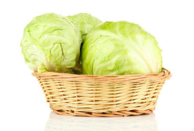綠色白菜在柳條籃子里，在白色隔離