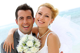 性格开朗的已婚的夫妇站在海滩上
