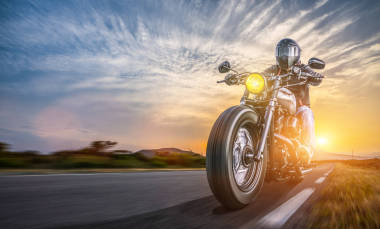 騎摩托車在路上騎。有樂趣駕駛空高