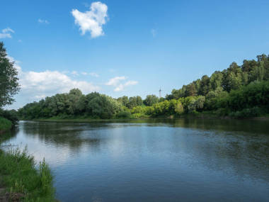 美丽的夏日。在阳光明媚的日子里，蓝天映照在一条深河里。云在天空中