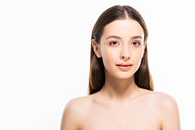 美丽的裸体女人与完美的皮肤看着相机孤立在白色