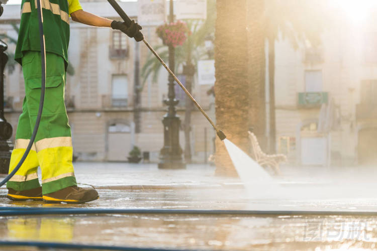 工人用高壓汽油清洗機清潔城市街道濺起污垢，專業(yè)清潔服務。高壓清潔，下體